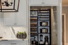 a small pantry with dark-stained shelves and baskets for organizing is a smart solution, and it’s hidden in a cool way