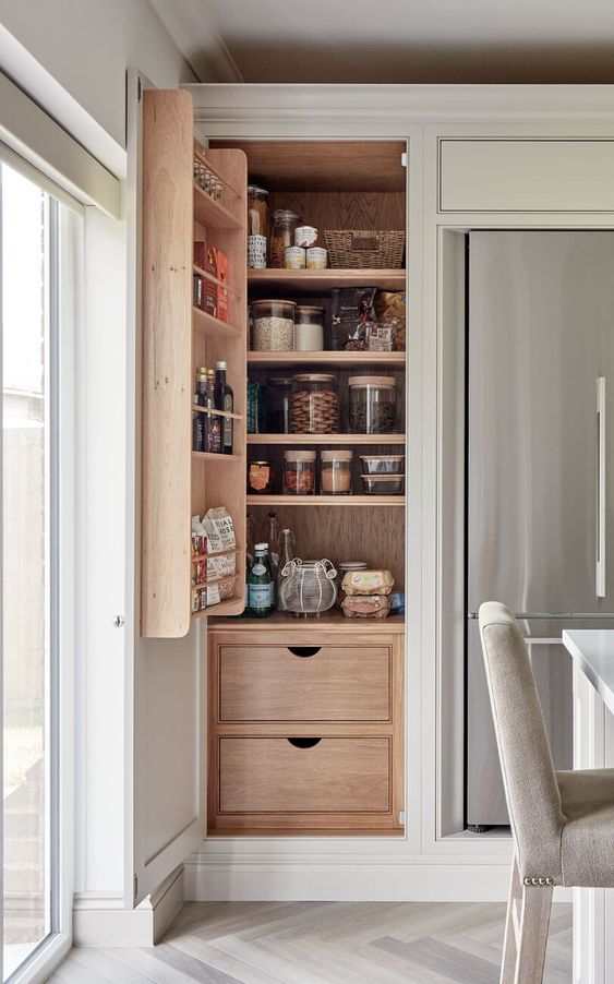 A small yet smart built in pantry with shelves, drawers and shelves on the doors, with food in matching jars is perfect