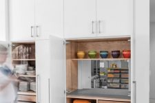a smart built-in pantry with open shelves, drawers, a mirror, some appliances and tableware is a lovely solution