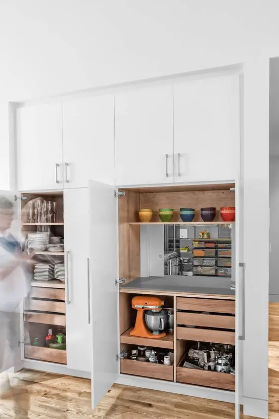 A smart built in pantry with open shelves, drawers, a mirror, some appliances and tableware is a lovely solution