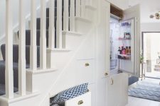 a staircase with built-in drawers and even a fridge to make it seamless and to save some floor space in the kitchen