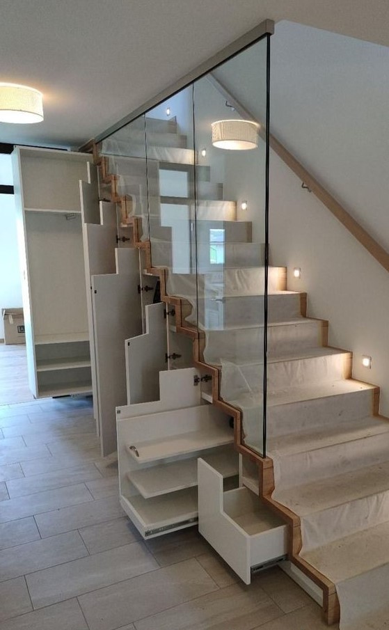 a staircase with built-in drawers and storage units is a very modern and smart solution for a space