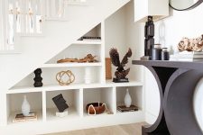 a staircase with built-in open storage compartments that are used for displaying and decorating is a very chic solution