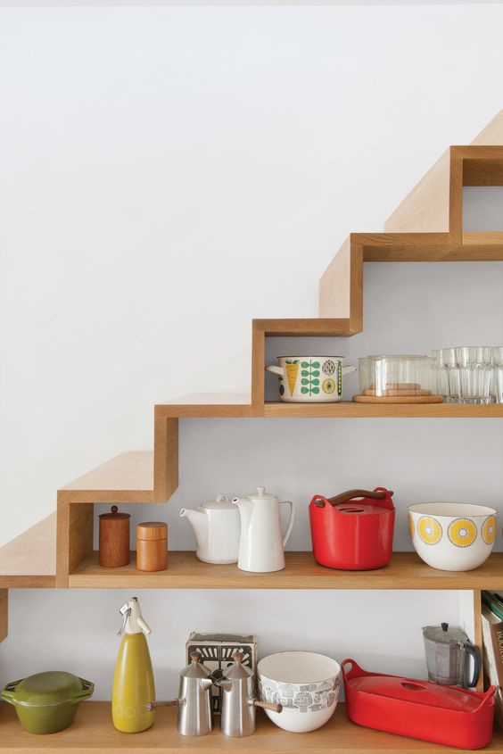 A staircase with built in open storage compartments that are used for storage and display is a smart idea for a kitchen