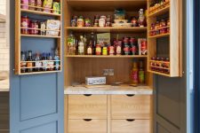 a stylish and comfortable pantry with stained shelves, shelves on the doors, drawers with labels what’s inside and lots of  food