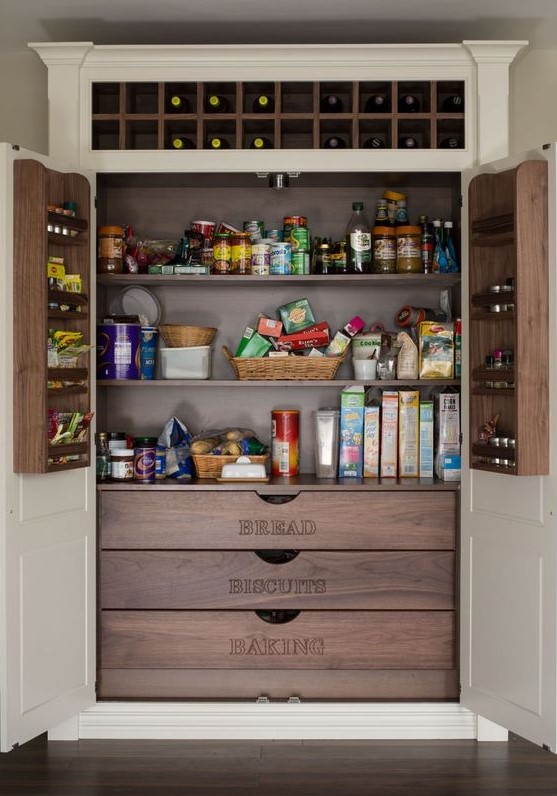 A stylish built in pantry with neutral doors and darker stained built ins   shelves, drawers and built in shelves