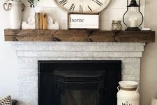 a vintage farmhouse fireplace of whitewashed brick, a dark-stained wooden mantel with pretty vintage decor