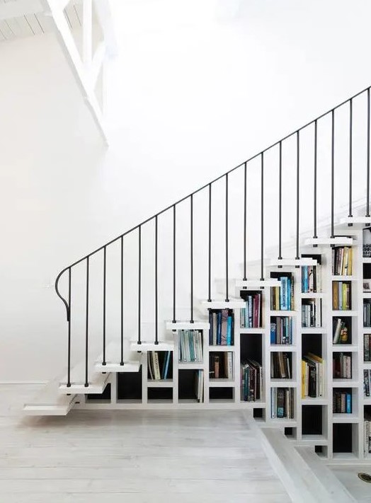 a white staircase that acts as a bookcase is all you need to save a lot of space in your home and show off your book collection