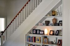 an open storage under built into the staircase is a cool bookcase that doesn’t require any floor space