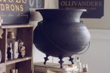 beautiful and geeky Halloween decor with an elegant cauldron, a sign, some apothecary tubes and a blackbird for Harry Potter fans