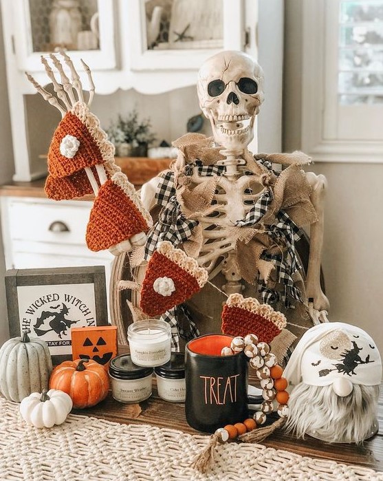 classic Halloween decor with a skeleton, a crocheted pumpkin pie garland, pumpkins, candles and beads is lovely