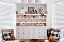 classic black and orange Halloween decor with pumpkins, a bold banner, some pumpkin dolls and bats