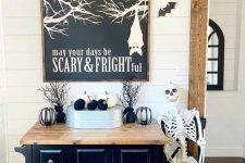 classic black and white Halloween decor with bats, black and white pumpkins, a skeleton and a cool sign