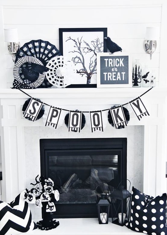 classic black and white Halloween fireplace decor with paper doilies, fake birds, candle lanterns, a bunting and a mini tree