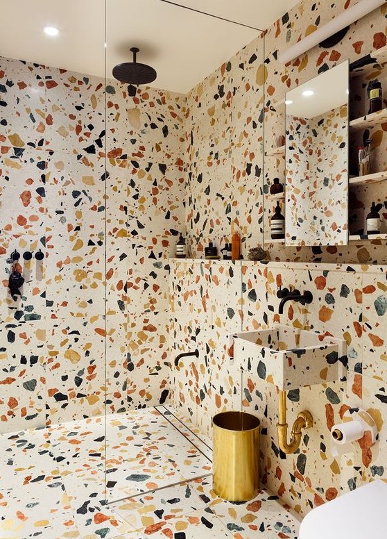 colorful spotted terrazzo that covers the walls, the floor and even shelves will make your bathroom very bright