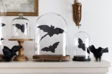 mantel decor with black bats in cloches and blackbirds is a cool and classic idea to style for Halloween