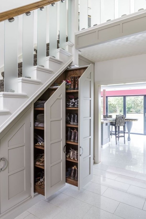 shoe storage with large drawers and an additional cabinet built into the staircase is a lovely idea