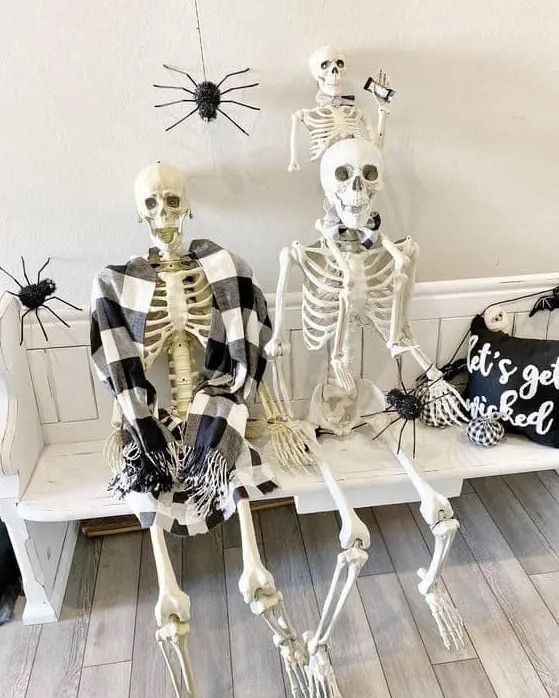 Skeletons on your entryway bench, with spiders around and a pillow will instantly make your entryway Halloween like