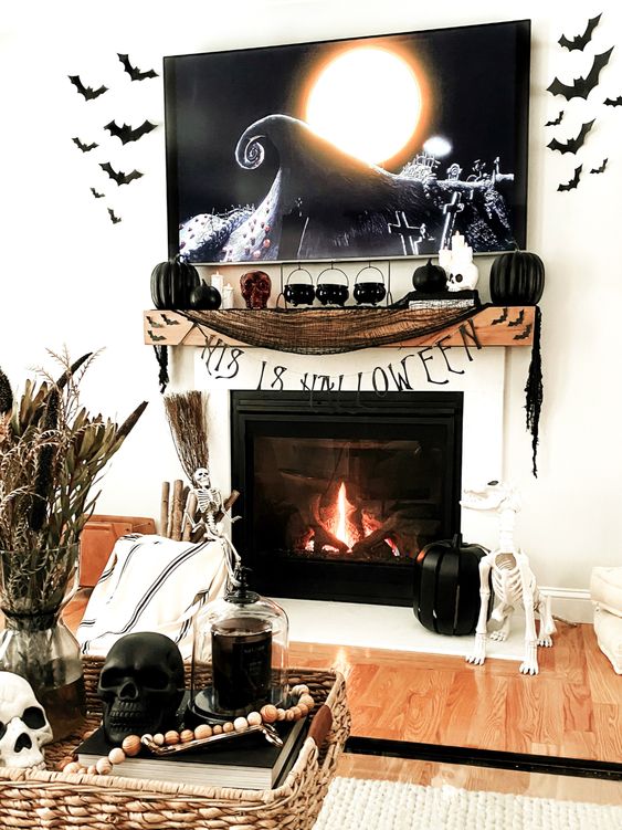 stylish classic Halloween decor with black bats, black pumpkins, candles, cauldrons, black cheesecloth, skulls and dried grasses
