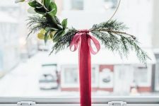 a Christmas wreath with evergreens, leaves and a red ribbon bow is a laconic holiday decoration to rock