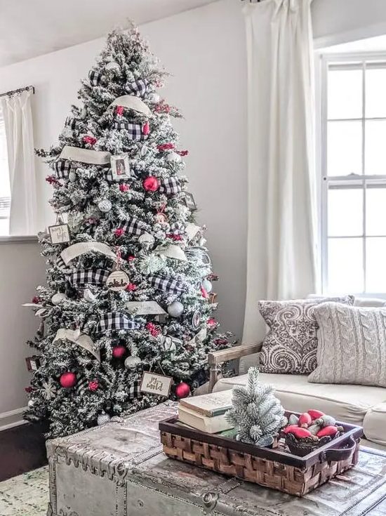 a beautiful flocked Christmas tree with a neutral and buffalo check ribbon, silver and red ornaments and photos