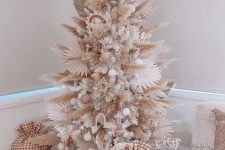a boho neutral Christmas tree with pampas grass and dried fronds, white and neutral ornaments, some wooden beads