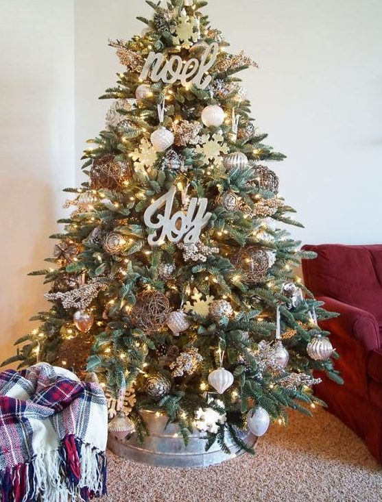 a chic farmhouse Christmas tree with lights, calligraphy, metallic ornaments, pinecones, snowflakes and with a metal base