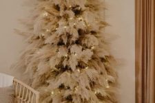 a classy boho Christmas tree with pampas grass and lights put in a basket is a cool idea for a boho space