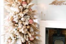 a creamy color pampas grass tree decorated with rose gold, gold and white ornaments plus blooms looks heavenly beautiful