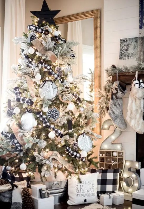 a farmhouse Christmas tree with burlap and buffalo check ribbons, oversized monograms and snowy pinecones, a black planked star topper