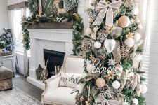 a farmhouse Christmas tree with burlap bows, wooden snowflakes, greenery and leaves and a star topper is a lovely idea