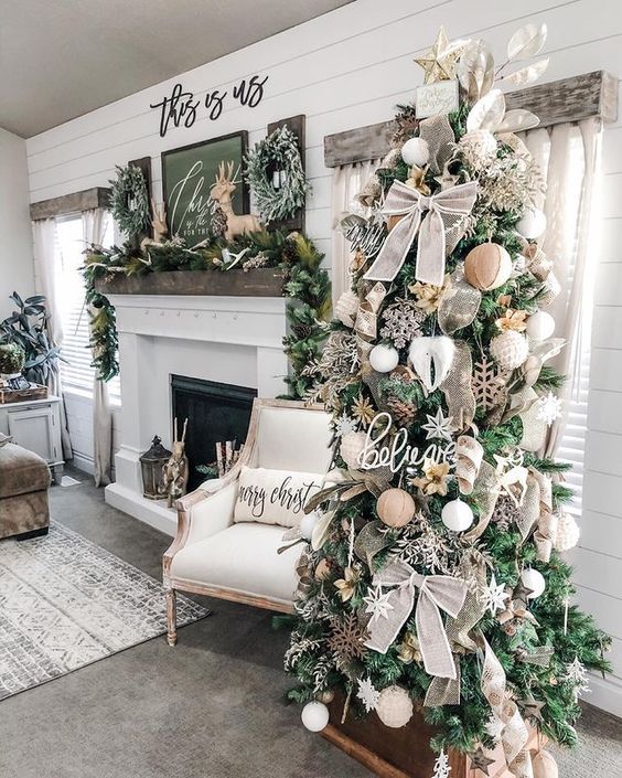 a farmhouse Christmas tree with burlap bows, wooden snowflakes, greenery and leaves and a star topper is a lovely idea