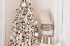 a farmhouse Christmas tree with wooden beads, burlap ribbons, white and fabric ornaments, and a star topper