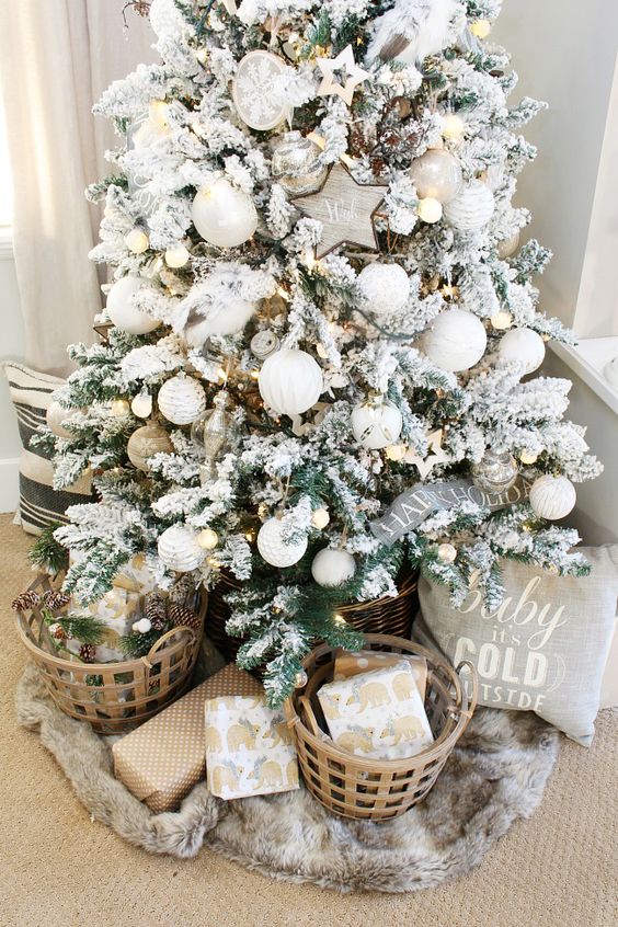 a farmhouse flocked Christmas tree with white ornaments, pinecones, lights and ribbon is a lovely idea