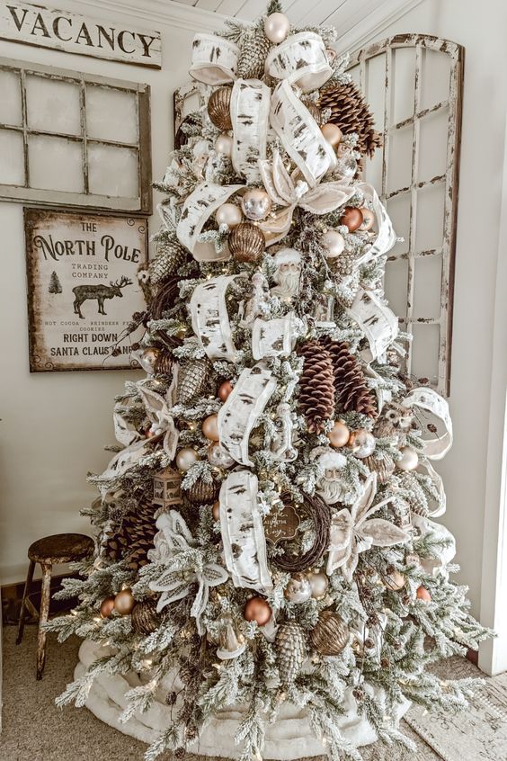 a flocked Christmas tree with pinecones, brown ornaments, ribbons and vine wreaths is a lovely idea for a farmhouse space
