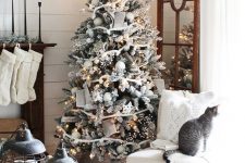 a flocked Christmas tree with ribbon, lights, white ornaments and snowflakes is a lovely and catchy idea