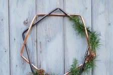 a geometric Christmas wreath with greenery and pinecones is a stylish and modern decor idea for the holidays