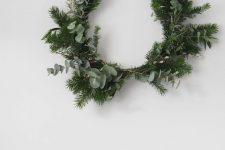 a modern Christmas wreath composed of a wire form, evergreens and eucalyptus is gorgeous and easy to make