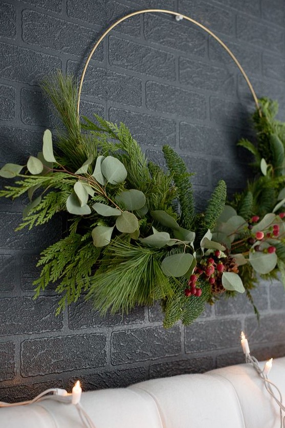 a modern Christmas wreath with evergreens and foliage plus berries is a stylish idea for a modern holiday space