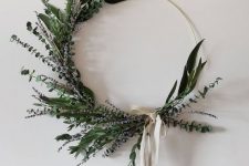 a modern and stylish Christmas wreath made with greenery and lavender, with a neutral ribbon bow is a catchy idea