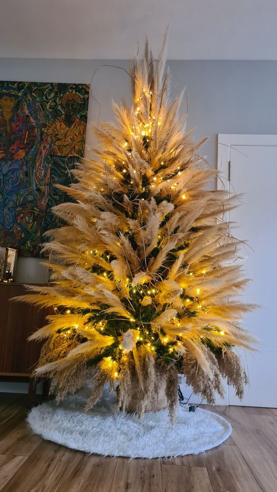 a pretty boho Christmas tree covered with pampas grass and lights is a cool idea for a boho Christmas space