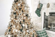 a pretty glam farmhouse Christmas tree with green bows, wooden ornaments, snowflakes, tinsel and branches and a basket