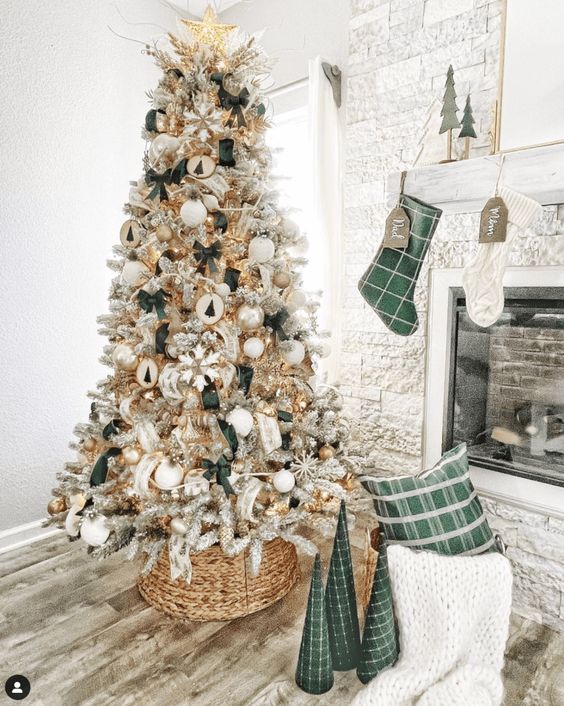 a pretty glam farmhouse Christmas tree with green bows, wooden ornaments, snowflakes, tinsel and branches and a basket