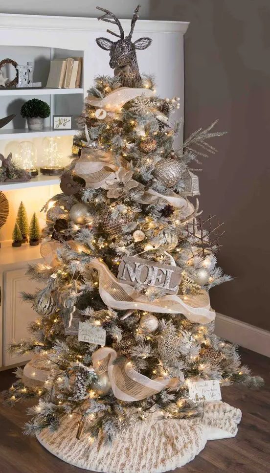 a rustic glam Christmas tree decorated with burlap, a vine deer head, wooden signs, stick snowflake ornaments and gold touches