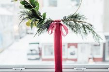 a simple and modern Christmas wreath with evergreens and greenery and a red ribbon bow is a catchy idea