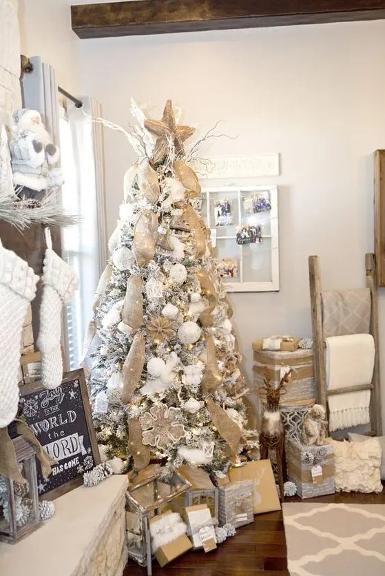 a snowy rustic Christmas tree with lots of burlap ribbons, burlap snowflake ornaments and white ornaments