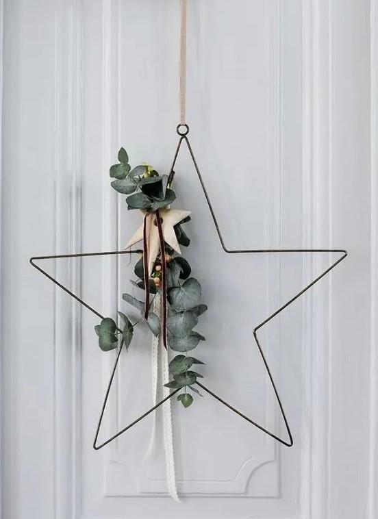 A star shaped Christmas wreath with eucalyptus, with wooden stars is a cool and contemporary idea for door decor