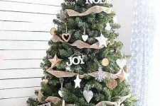 a super cozy Christmas tree with various star ornaments including wooden ones, burlap ribbons, snowflakes and hearts plus a basket cover