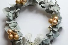 a super modern and bold eucalyptus and gold ornament wreath with a delicate ribbon bow is amazing for Christmas