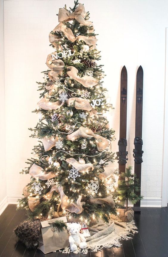 a woodland farmhouse Christmas tree with white snowflakes, lights, pinecones, letters and burlap ribbon is wow